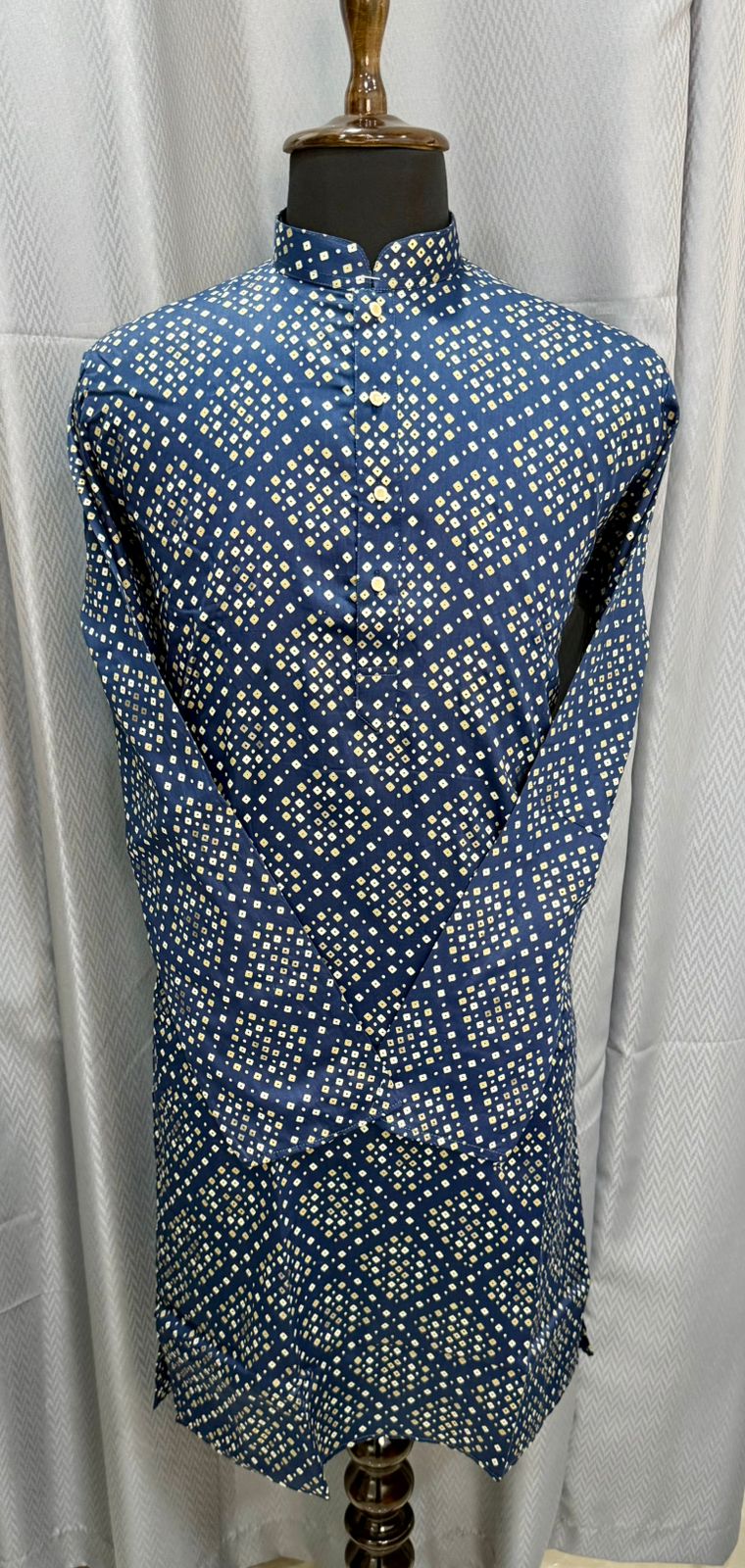 Blue bandhani themed kurta on a mannequin against a white curtain background