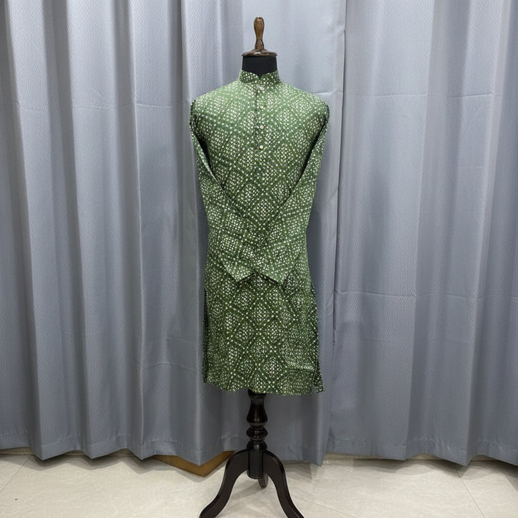 Green dress with white polka dots on a mannequin against a gray curtain background