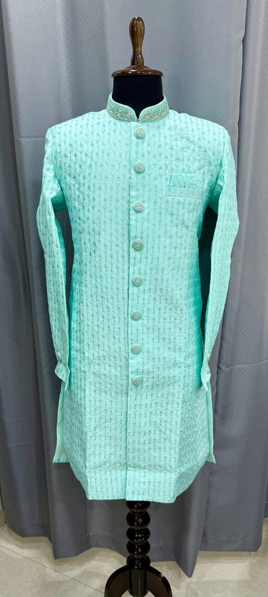 Light blue sherwani on a mannequin against a gray curtain background