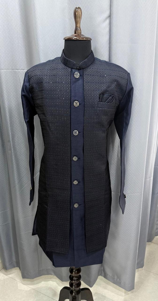 Dark blue sherwani on a mannequin against a light gray curtain background