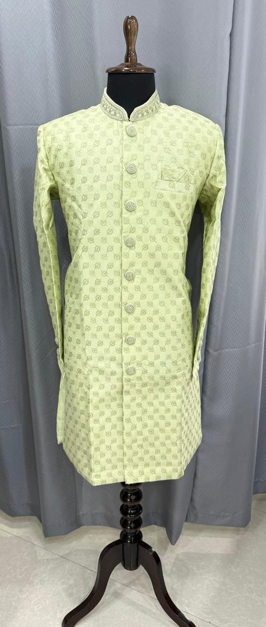 Light green hand work sherwani on a mannequin against a gray curtain background