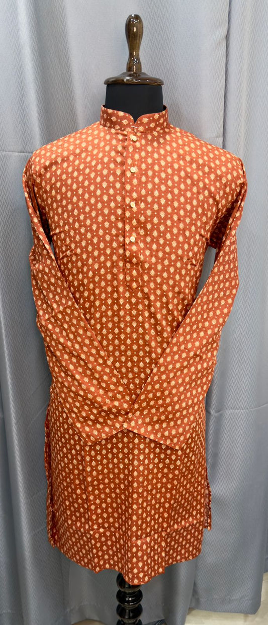 Orange dress with white polka dots on a mannequin against a gray curtain background