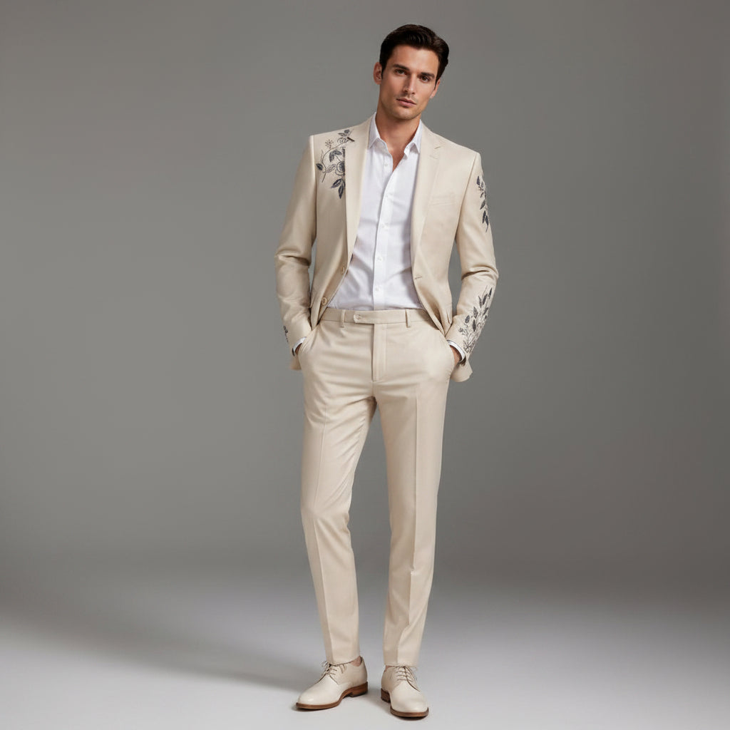 Man wearing a beige suit with floral embroidery on a gray background