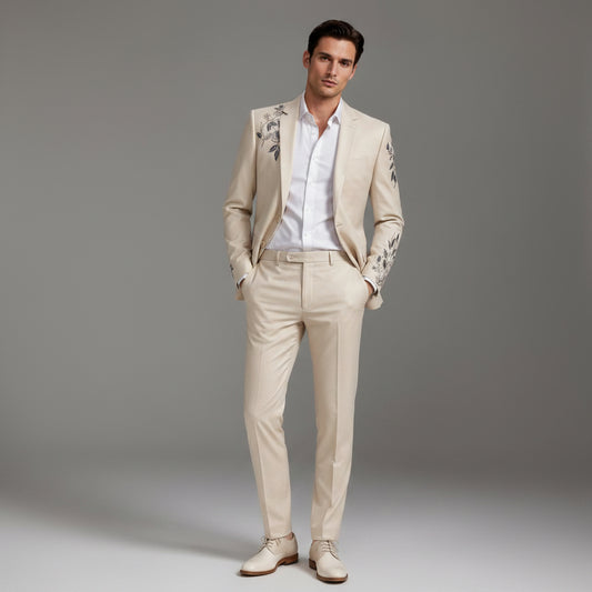 Man wearing a beige suit with floral embroidery on a gray background